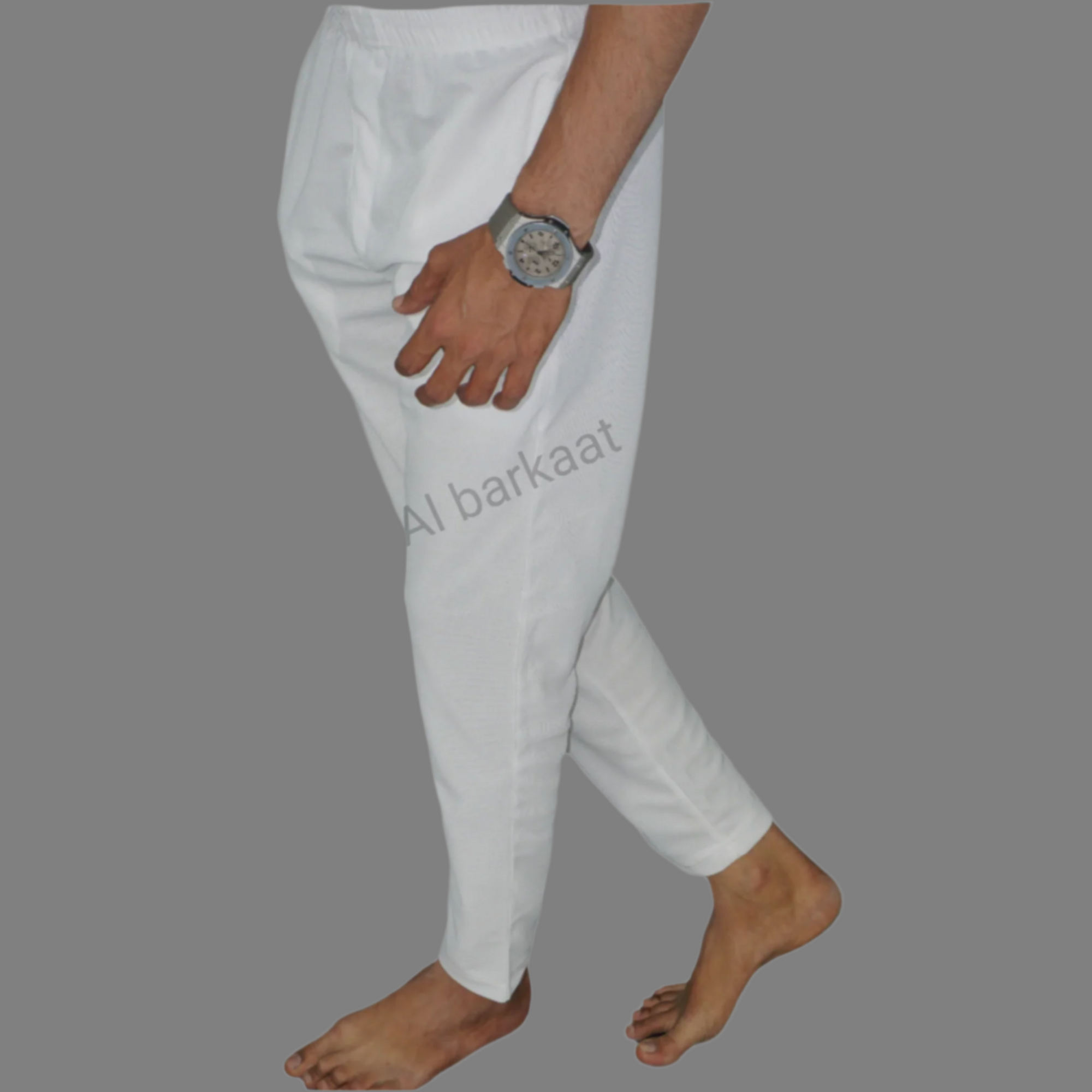Person wearing white pants on a green background with 'Al Barkaat' branding.